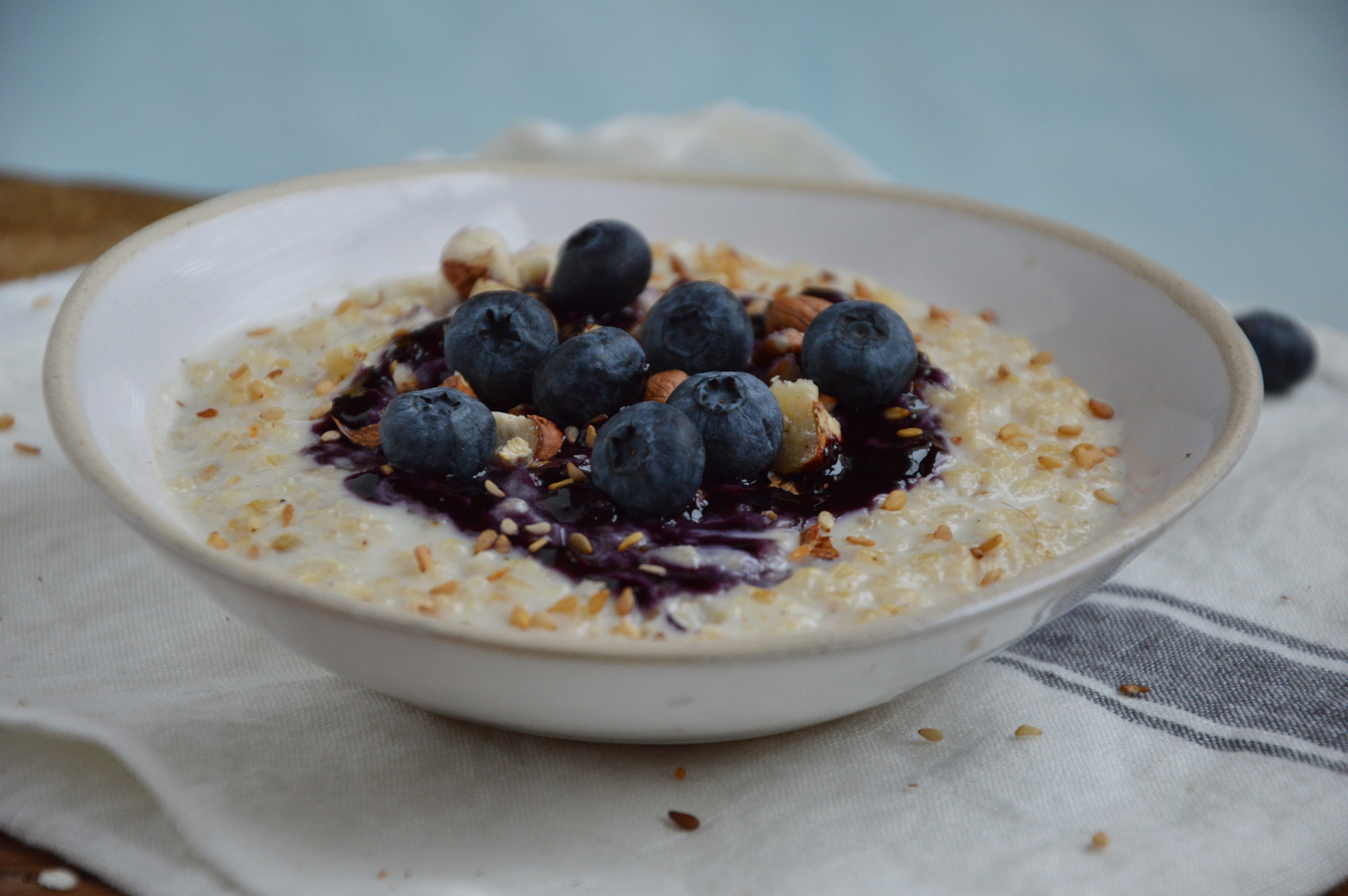 Vegan porridge au lait d’amande, flocons d’avoine, noisettes, sésame, myrtilles fraiche et